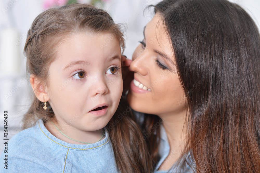 Close up portrait of little girl with mother hugging Close up portrait of little girl with mother hugging