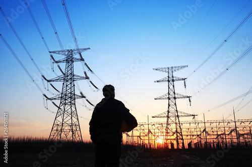 electricity workers and pylon silhouette