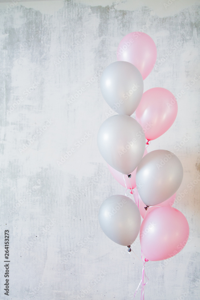 Vertical banner of bunch of pink and gray balloons for birthday party on gray concret background with copy space Vertical banner of bunch of pink and gray balloons for birthday party on gray concret background with copy space