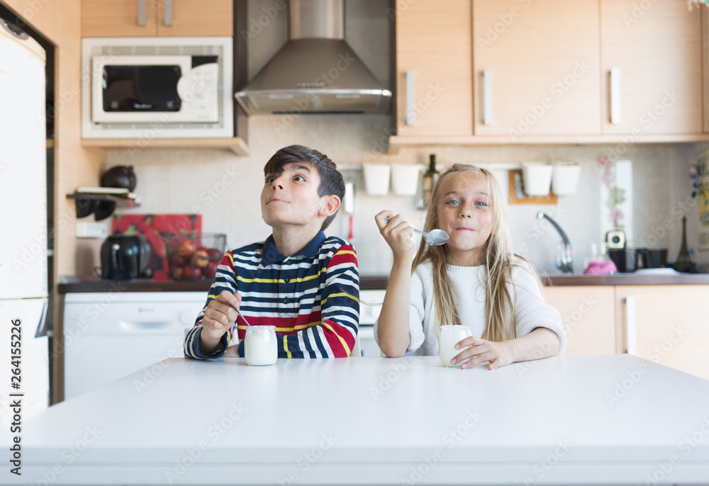 Happy children eating a yogurt. Happy children eating a yogurt.