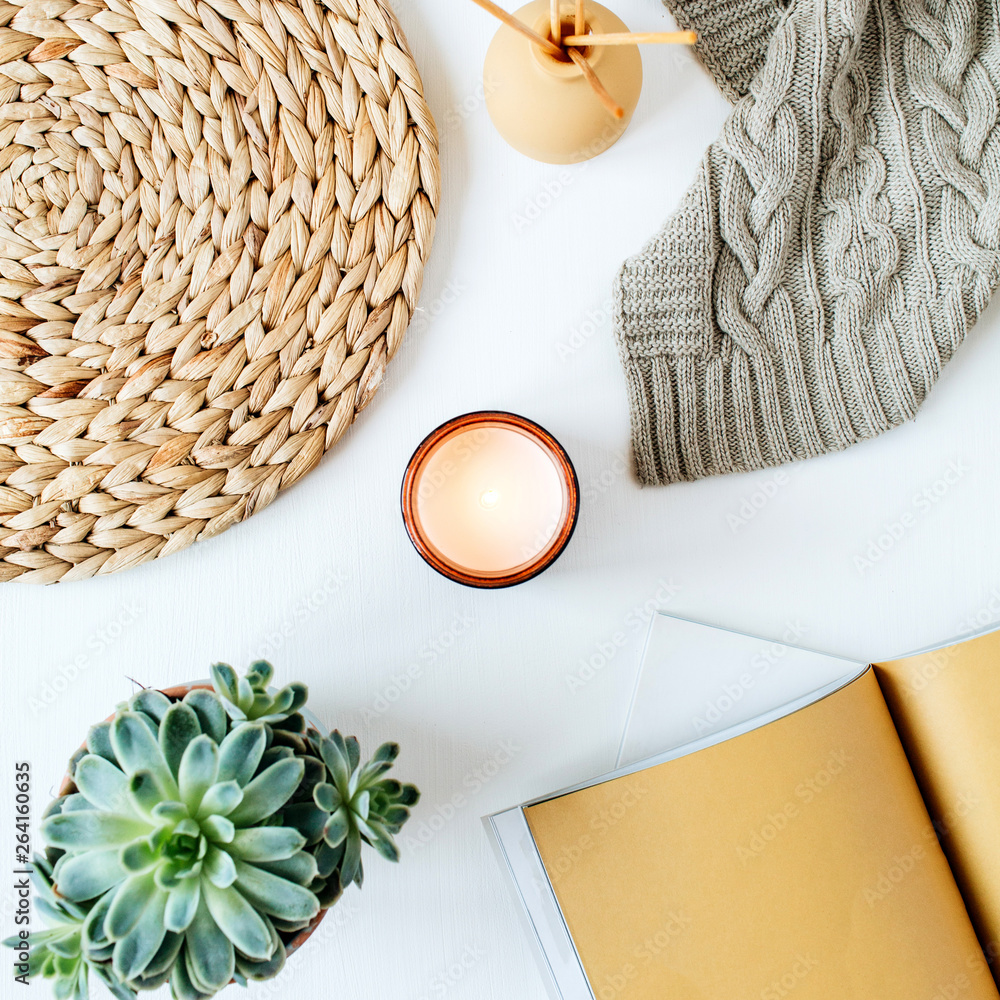 Boho style modern minimal home workspace desk with notebook, succulent,  knitted plaid, candle, aroma sticks, straw wicker napkins on white  background. Flat lay, top view bohemian lifestyle blog hero Stock Photo