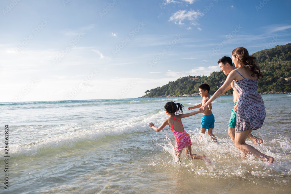 Happy young family running in sea water Happy young family running in sea water