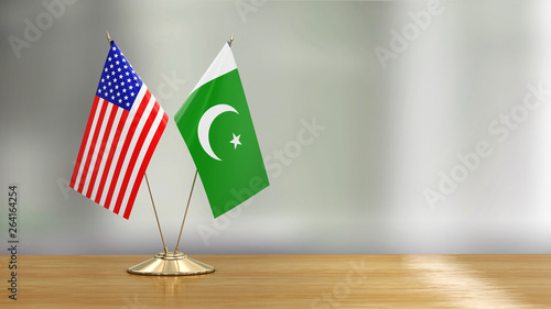 Bild auf Leinwand American and Pakistani flag pair on a desk over defocused background