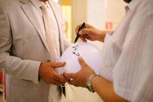 a man writes a marker with a balloon