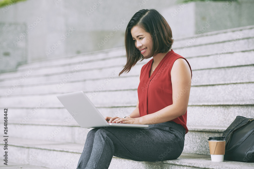 Woman using laptop outdoors Woman using laptop outdoors
