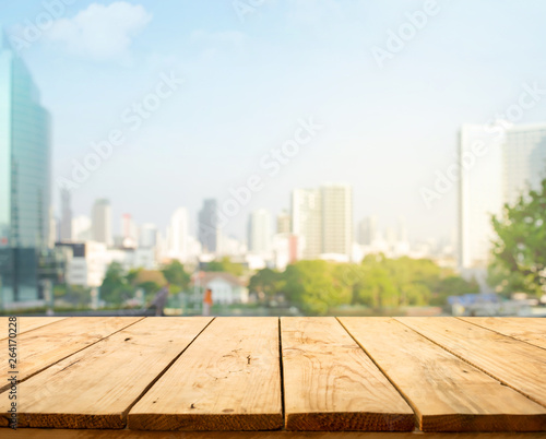 Wood table top on blur window glass wall background with city view.For montage product display or design key visual