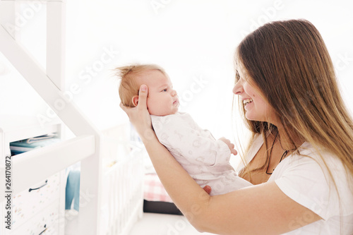 Mother holds her newborn son in back light. Family and security concept