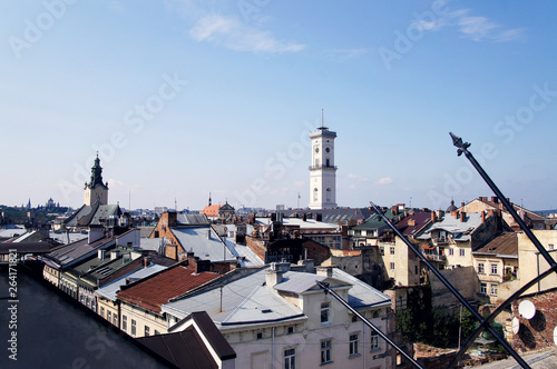 Roofs of an old European city architecture against the blue sky. Top view of the streets.