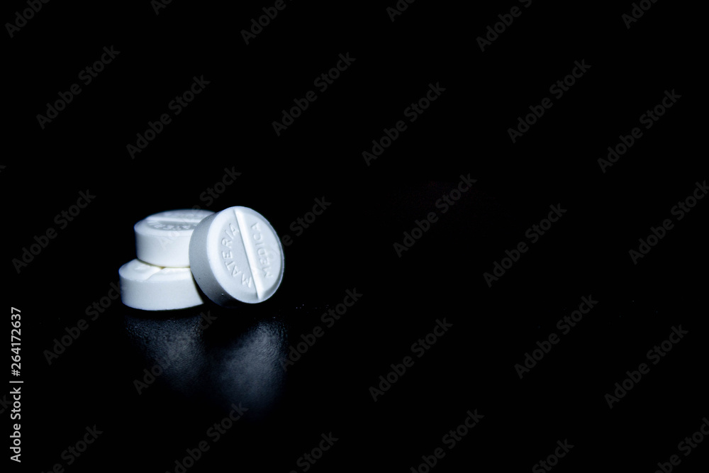 white pills on black glass background. medical pharmacy white pills on black glass background. medical pharmacy
