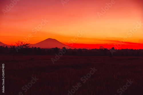 Bright colorful sunset with silhouette of volcano in Bali © artifirsov