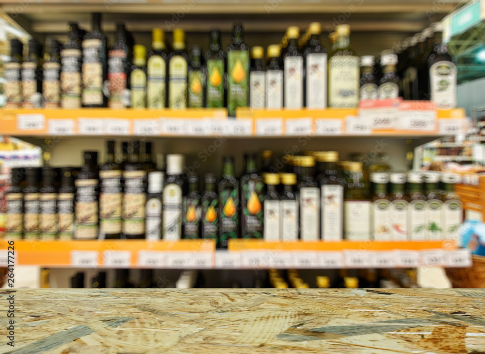 Grocery store. Shelves with olive, rapeseed and sunflower oil. Defocused, blurred image.