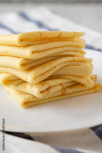 Pile of tasty blini on a white plate, side view. Closeup.