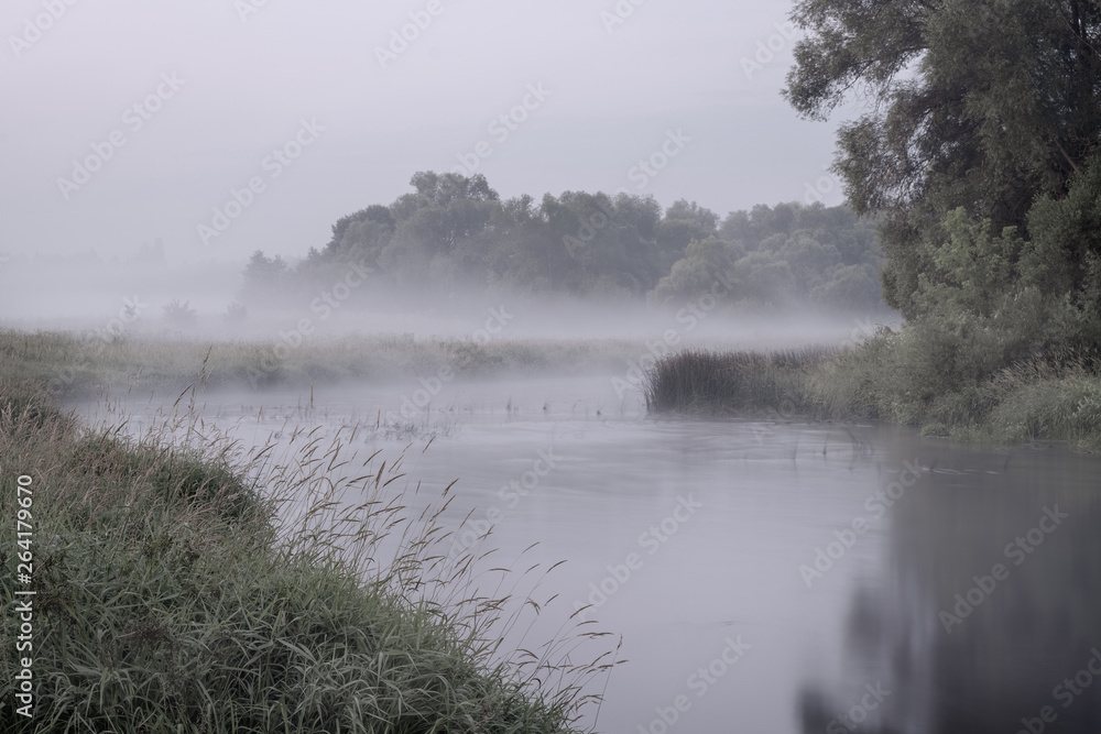 Fototapeta premium Fog at dusk on the river in the early morning