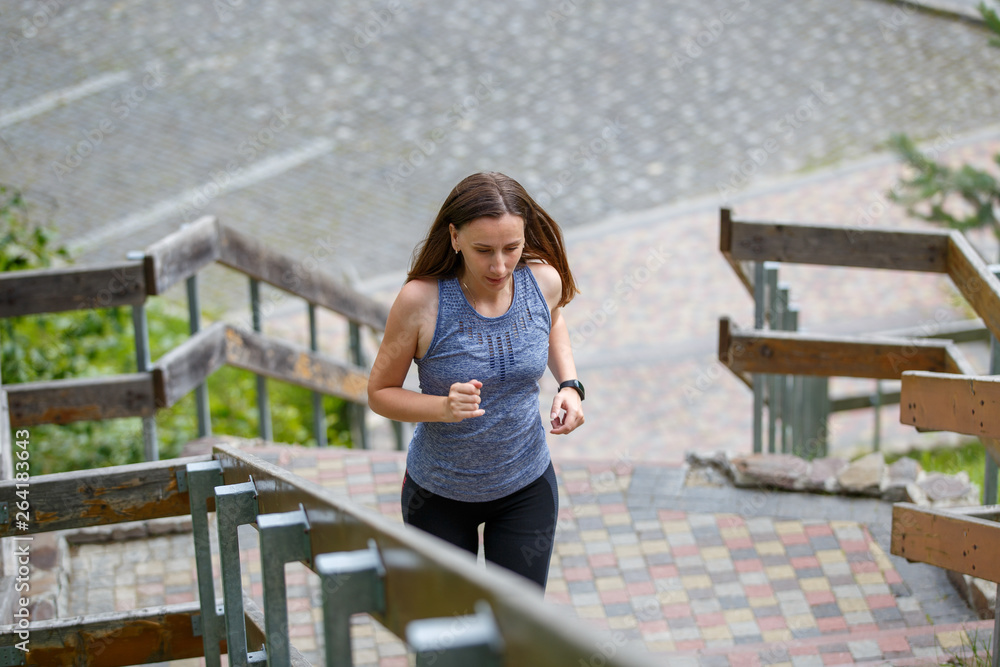 Young running woman ascending stairs in the morning