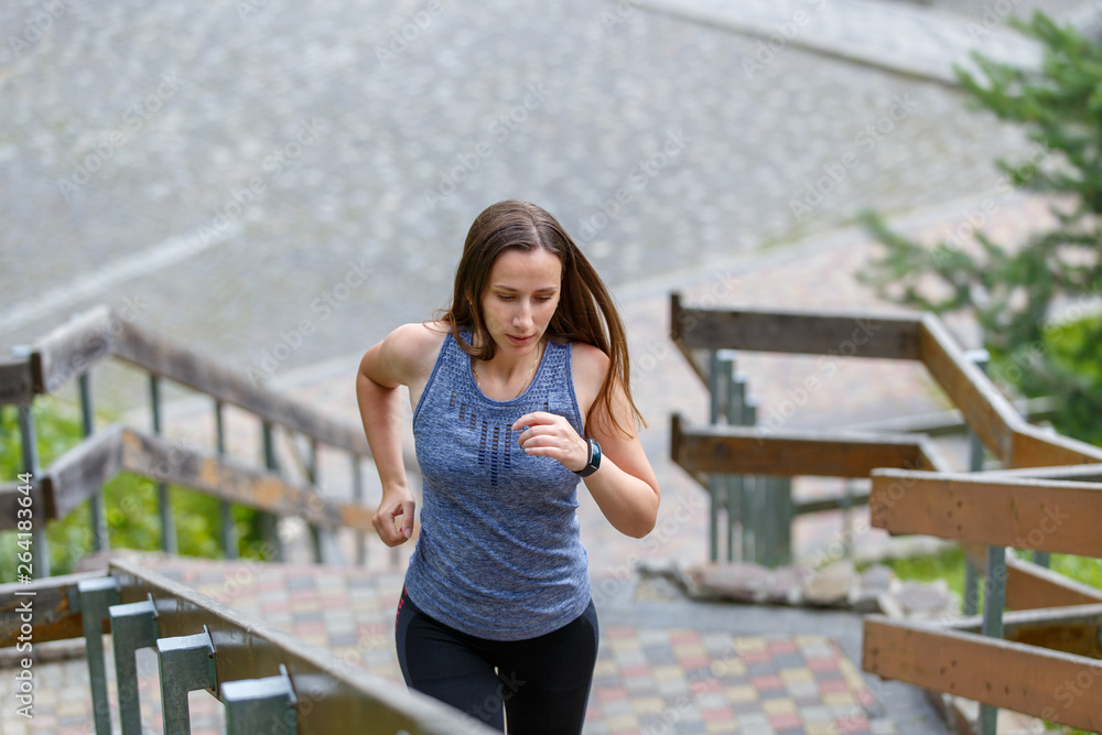 Obraz premium Young running woman ascending stairs in the morning