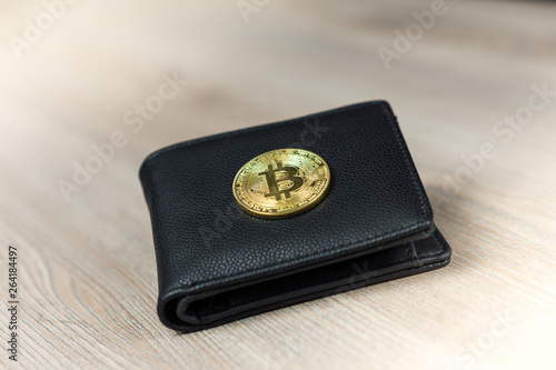 Metal bitcoins in black leather wallet. Bitcoin - modern virtual