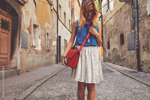 Cute attractive fashionable woman posing in the old European street. Fashion details. © Kitja