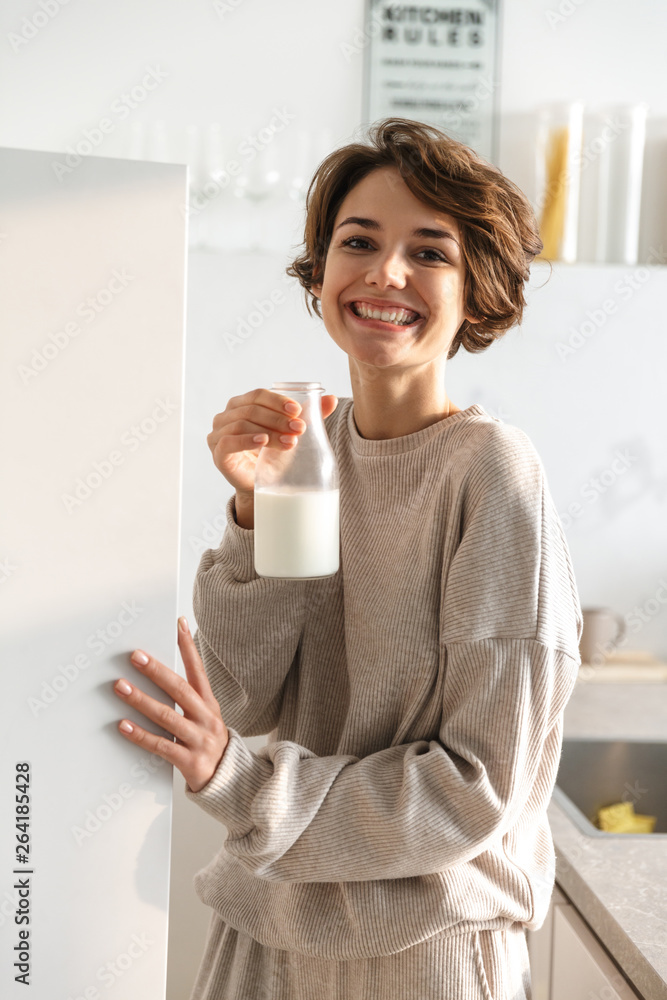 Vertical image of Smiling brunette woman drinking milk Vertical image of Smiling brunette woman drinking milk