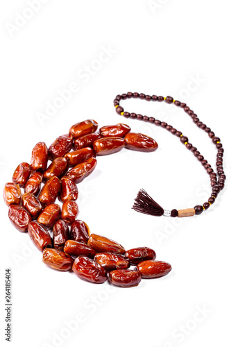 Dried dates laid out in the shape of a Crescent on a white background. The concept of the Holy Muslim month of Ramadan Karim