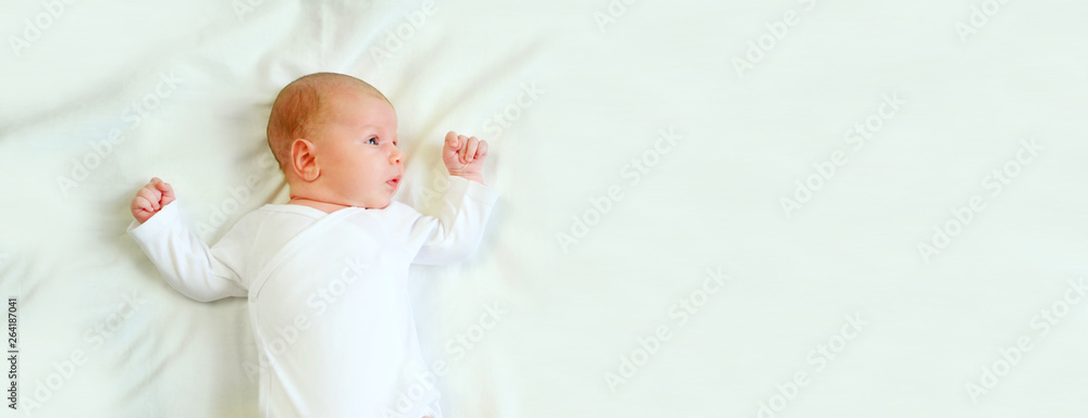 Banner portrait little baby boy newborn 1 months old in white clothes lying on his back in his crib. Concept of health and children. Selective focus. Banner portrait little baby boy newborn 1 months old in white clothes lying on his back in his crib. Concept of health and children. Selective focus.