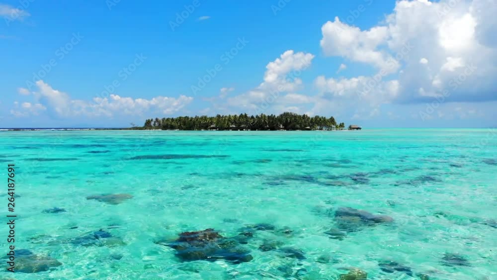 Aerial Forward: Vibrant Blue Ocean Leading Up To Palm Tree Island in Vahine, French Polynesia Aerial Forward: Vibrant Blue Ocean Leading Up To Palm Tree Island in Vahine, French Polynesia