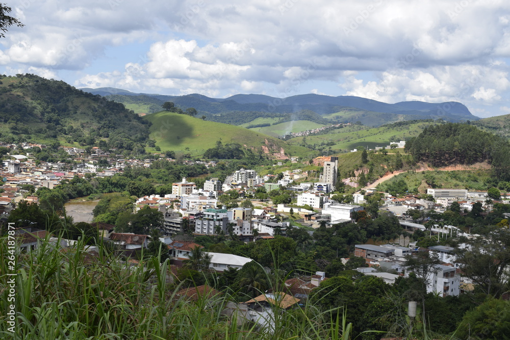 Paisagem aérea de cidade entre montes verdes. Cidade de Nova Era em Minas Gerais.