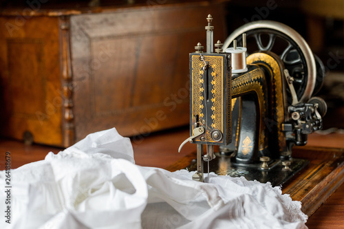 Process of sewing on the ancient sewing machine in the antiquarian case. Soft focus. 