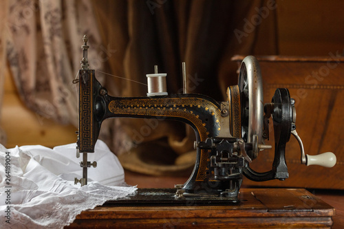 Process of sewing on the ancient sewing machine in the antiquarian case. Soft focus. 