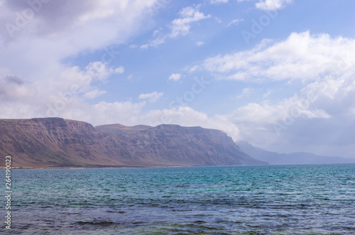 Cliffs of Lanzarote seen from a beach on the island of La Graciosa