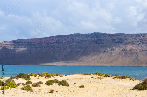 Cliffs of Lanzarote seen from a beach on the island of La Graciosa