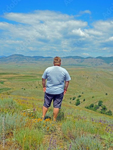 Man looks at the valley and the vineyards from a height