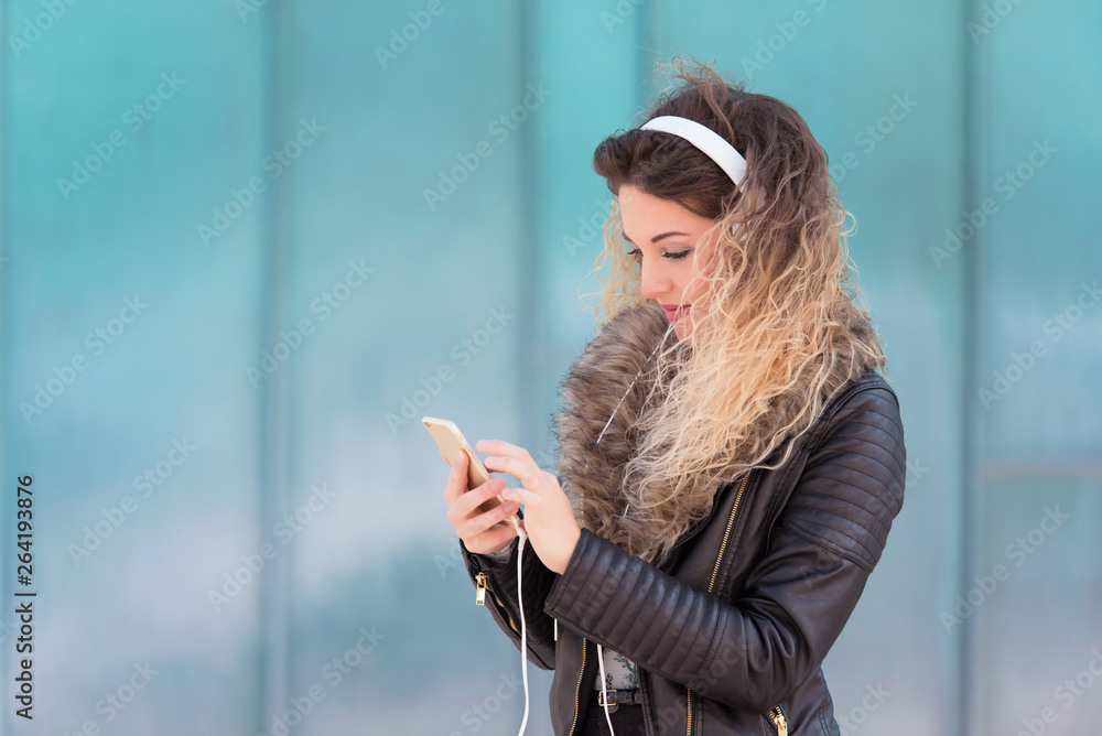 Fototapeta premium Young woman listening music with her headphones
