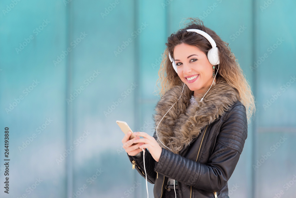 Young woman listening music with her headphones