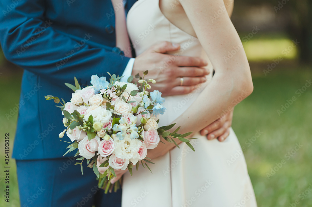 Closeup with bride and groom hands and bouquet. Bride, holding a wedding bouquet of flowers Wedding gold rings. Hand of a girl with a bouquet of flowers. flowers on the wedding day Closeup with bride and groom hands and bouquet. Bride, holding a wedding bouquet of flowers Wedding gold rings. Hand of a girl with a bouquet of flowers. flowers on the wedding day