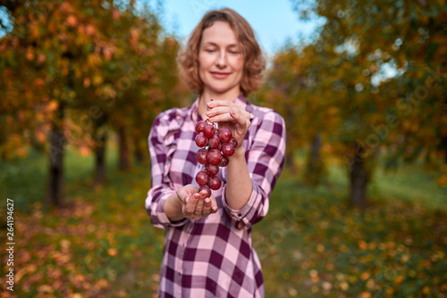 Cute woman with grapes in her hands in the garden 