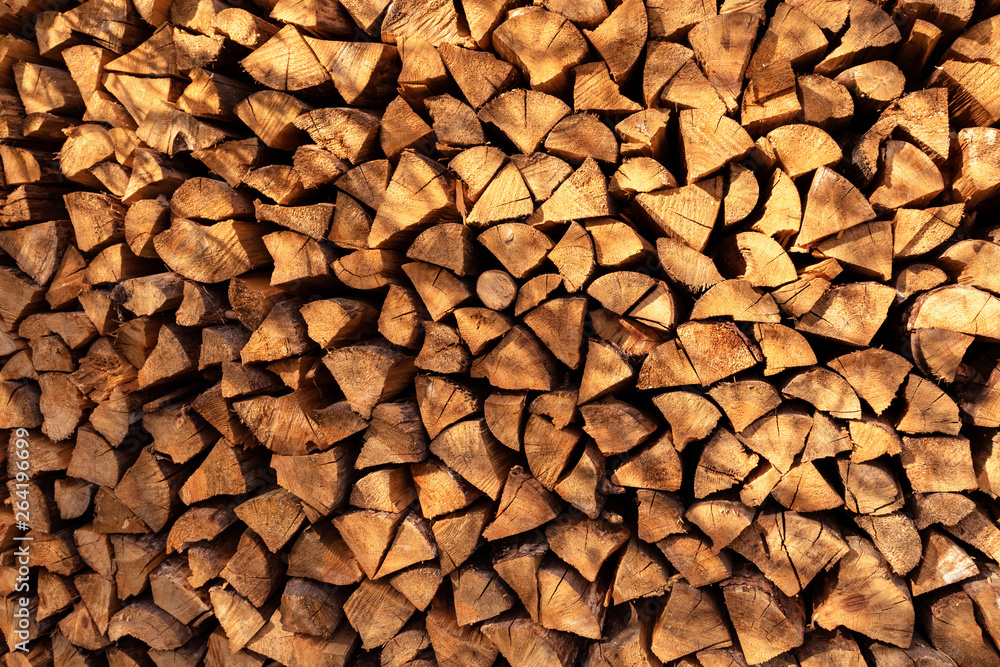 Background of dry chopped firewood, stacked wood trunks for winter heating fireplace. Background of dry chopped firewood, stacked wood trunks for winter heating fireplace.