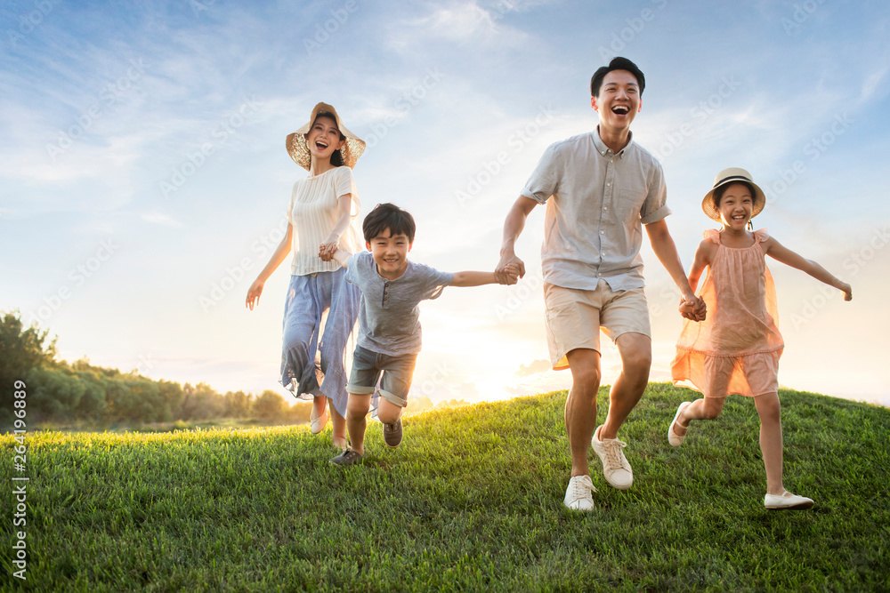 Happy young family running on meadow Happy young family running on meadow