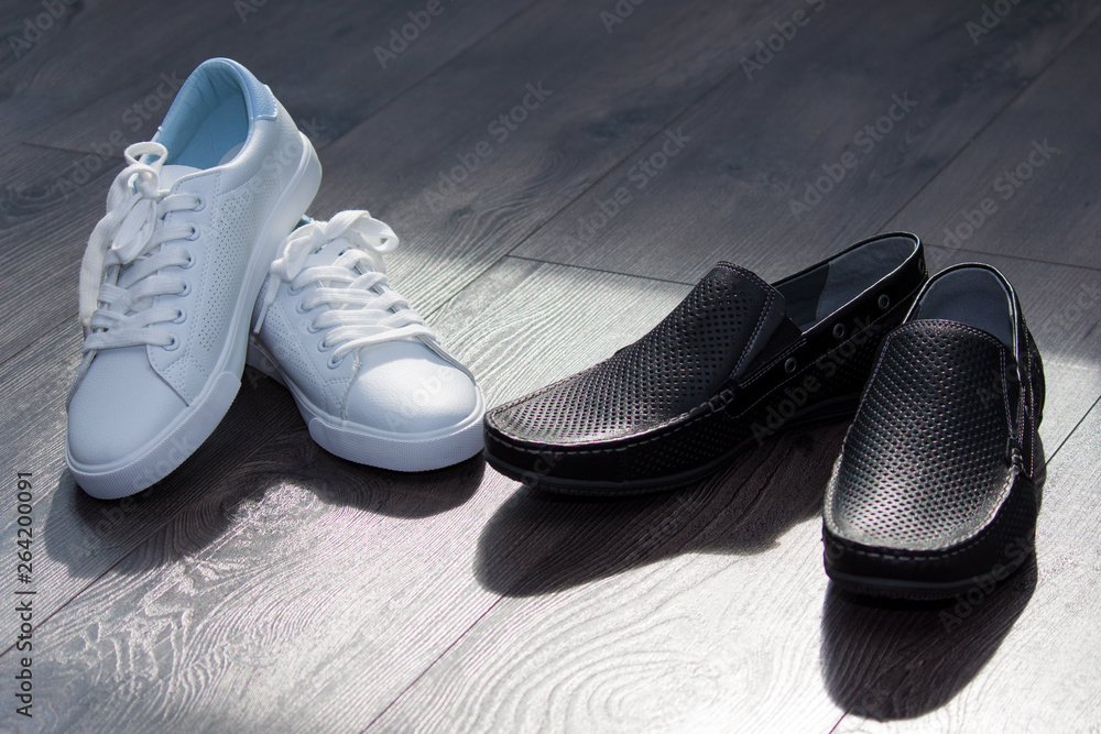 Couple of man black shoes and woman white sneakers. Fall in love, attention, watch concept. Couple of man black shoes and woman white sneakers. Fall in love, attention, watch concept.