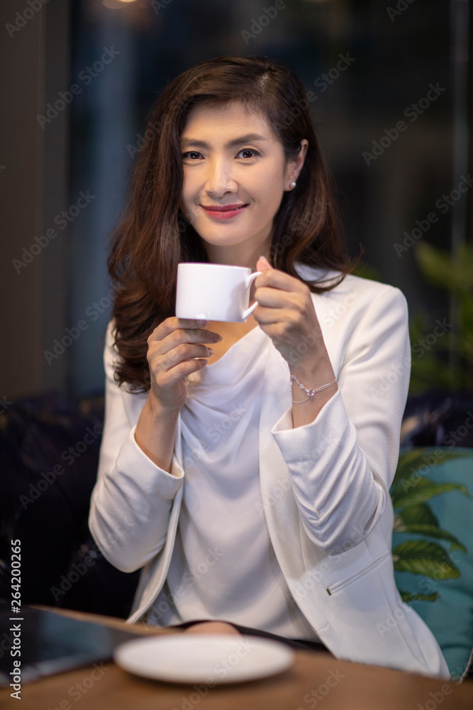 Businesswoman drinking coffee in caf�� Businesswoman drinking coffee in caf��