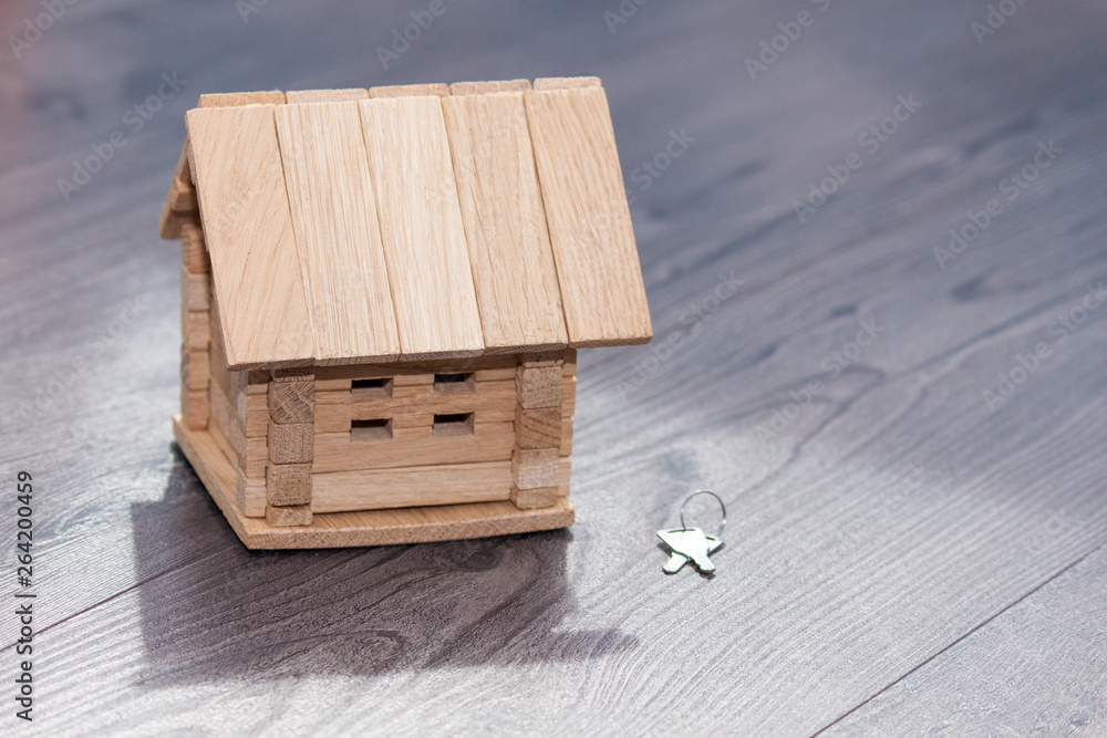 Fototapeta premium Closeup of wooden house model and silver keys on wooden background.