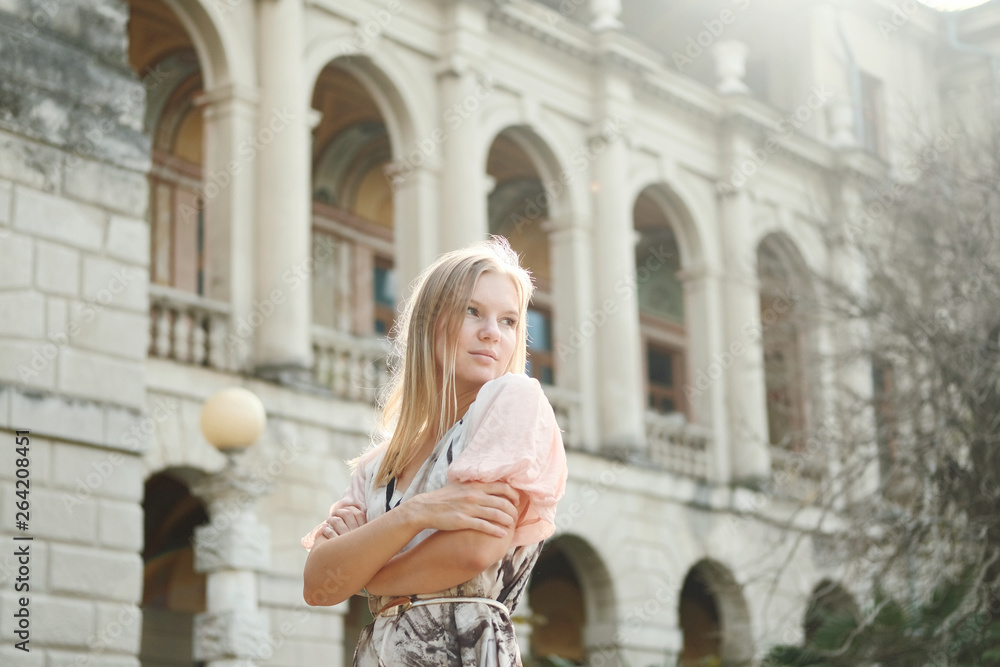 Fototapeta premium Beautiful blond girl posing at the park in dress
