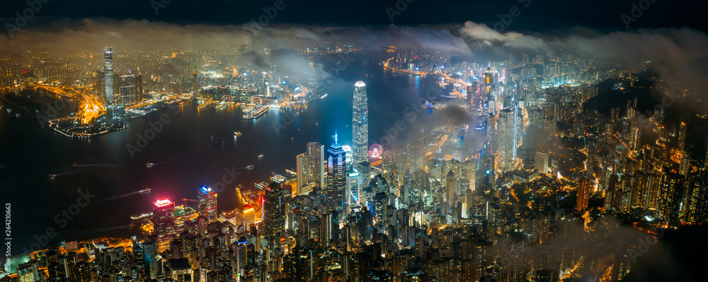 Panorama aerial view of Hong Kong City skyline at night over the clouds