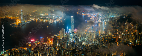 Panorama aerial view of Hong Kong City skyline at night over the clouds