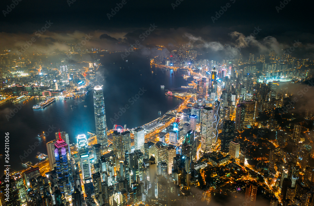 Aerial view of Hong Kong City skyline at night over the clouds