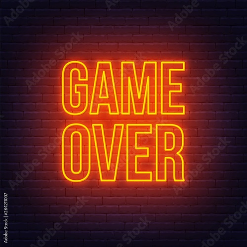 Neon game over sign on brick wall background.