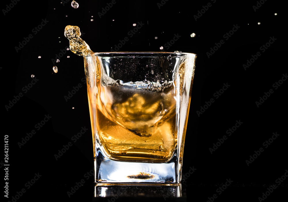 whiskey with ice in a steaming glass on a black background whiskey with ice in a steaming glass on a black background