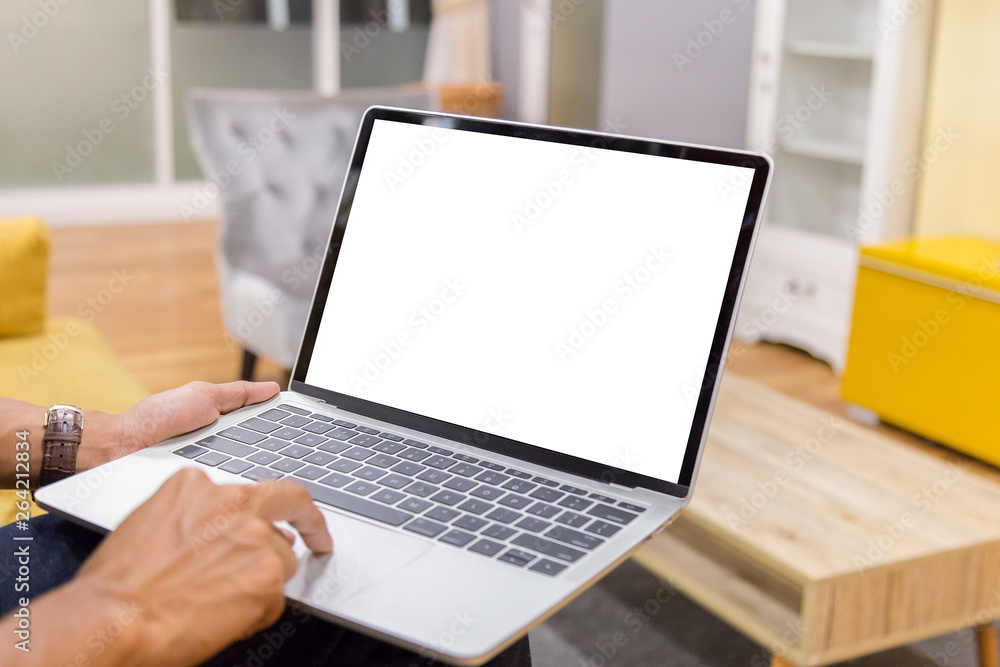 Mockup image of a businessman using laptop with blank white desktop screen working in home- Image Mockup image of a businessman using laptop with blank white desktop screen working in home- Image