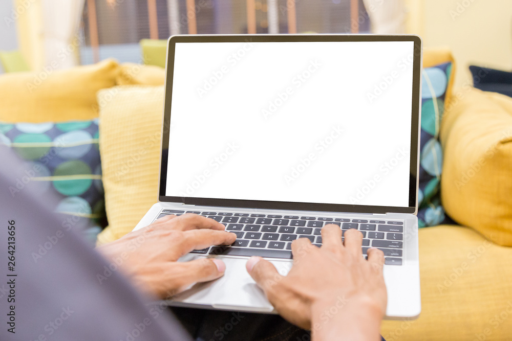 Mockup image of a businessman using laptop with blank white desktop screen working in home- Image Mockup image of a businessman using laptop with blank white desktop screen working in home- Image