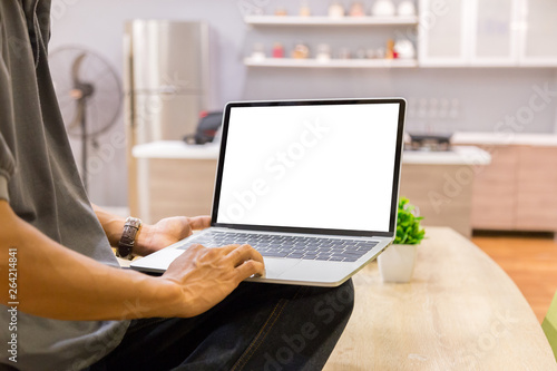 Mockup image of a businessman using laptop with blank white desktop screen working in home- Image