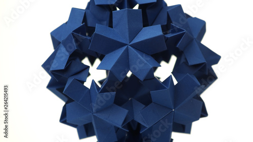 Sperical modular origami object. Close up blue origami ball isolated on white background. Japanese artwork and traditions.